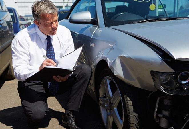 smiling couple receiving auto insurance paperwork